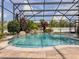 Screened-in pool features a rock waterfall, lush landscaping, and clear turquoise water for relaxation at 1861 Remembrance Ave, St Cloud, FL 34769