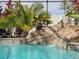 Close-up of a pool with rock waterfall, lush tropical foliage, and clear turquoise water at 1861 Remembrance Ave, St Cloud, FL 34769