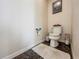 Small toilet room with toilet, toilet paper holder, and a small white floor mat at 1861 Remembrance Ave, St Cloud, FL 34769