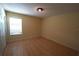 Bedroom with wood floors, closet, and a window with blinds at 2007 Country Brook Ave, Clermont, FL 34711