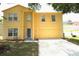 Two-story yellow home featuring an attached garage and well-maintained lawn at 2007 Country Brook Ave, Clermont, FL 34711