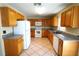 Well-lit kitchen with granite countertops, white appliances, and wood cabinets at 2007 Country Brook Ave, Clermont, FL 34711