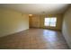 Spacious living room featuring neutral tile flooring, a large window, and fresh, neutral paint at 2007 Country Brook Ave, Clermont, FL 34711