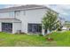 Backyard showing the rear of the home with a screened in patio and green space at 212 Primrose Dr, Davenport, FL 33837