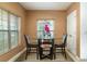 Cozy dining area with a glass-top table, comfortable chairs, and natural light from the windows at 212 Primrose Dr, Davenport, FL 33837