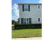 Two-story home featuring gray siding, dark shutters, manicured lawn and hedges at 212 Primrose Dr, Davenport, FL 33837