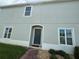 Gray two-story home with a dark front door and brick walkway at 212 Primrose Dr, Davenport, FL 33837