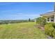 A backyard view of rolling green hills with lush trees lining the horizon at 2147 Timber Creek Ln, Clermont, FL 34715