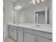 A sleek bathroom featuring dual sinks, quartz countertops, and a large mirror at 2147 Timber Creek Ln, Clermont, FL 34715