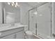 Bathroom featuring white vanity, shower with glass doors, light tile surround, and a framed mirror at 2147 Timber Creek Ln, Clermont, FL 34715