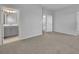 Bedroom featuring neutral carpet, walls, and open doorway to the bathroom with a gray vanity and tiled floors at 2147 Timber Creek Ln, Clermont, FL 34715
