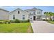 Attractive two-story home with brick driveway, two-car garage, lush landscaping and front entryway at 2147 Timber Creek Ln, Clermont, FL 34715
