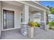 Covered front porch with brick columns, gray door and a neatly tiled floor surface at 2147 Timber Creek Ln, Clermont, FL 34715