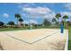 Enjoy a community sand volleyball court with tropical landscaping and a glimpse of neighborhood homes in the background at 2147 Timber Creek Ln, Clermont, FL 34715