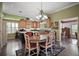 Well-lit kitchen and dining area with hardwood floors, custom cabinetry, and a chandelier at 215 Chula Vista Ave, The Villages, FL 32159