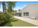 The screened-in porch sits off a concrete patio and beautifully landscaped yard with palm trees at 2312 Nackman Pl, The Villages, FL 32162