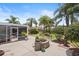 Well-maintained backyard featuring a screened-in patio and lush landscaping at 2312 Nackman Pl, The Villages, FL 32162