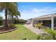 Spacious backyard with lush landscaping, outdoor seating, and a covered patio area, ideal for entertaining guests at 2312 Nackman Pl, The Villages, FL 32162