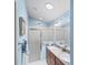 Bathroom with updated double vanity, framed mirrors, framed art and walk-in shower at 2312 Nackman Pl, The Villages, FL 32162