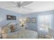 Comfortable bedroom with light blue walls, white trim, and a sheer curtain letting in natural light at 2312 Nackman Pl, The Villages, FL 32162