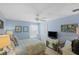 Bright bedroom with blue walls, ceiling fan, and a television atop a decorative dresser at 2312 Nackman Pl, The Villages, FL 32162