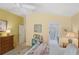 Bright bedroom features neutral paint, ceiling fan, ensuite bathroom and comfortable decor at 2312 Nackman Pl, The Villages, FL 32162