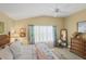 Bright, light-filled bedroom features tropical curtains, comfy bed and neutral paint at 2312 Nackman Pl, The Villages, FL 32162