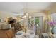 Cozy dining area adjacent to living room, featuring a chandelier and sliding door access to outdoor patio at 2312 Nackman Pl, The Villages, FL 32162