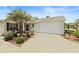 Inviting home exterior featuring a driveway, garage, and manicured landscaping, exuding curb appeal at 2312 Nackman Pl, The Villages, FL 32162