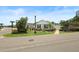 Charming home with well-maintained lawn and landscaping, complemented by a corner street view and bright blue sky at 2312 Nackman Pl, The Villages, FL 32162