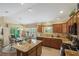 Bright kitchen with a central island, granite countertops, and seamless flow into dining area and outdoor patio at 2312 Nackman Pl, The Villages, FL 32162
