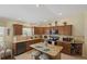 Spacious kitchen boasting granite counters, custom cabinets, tile backsplash, and central island with seating at 2312 Nackman Pl, The Villages, FL 32162