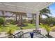 Covered patio area with stylish outdoor furniture, and a view of the meticulously landscaped yard at 2312 Nackman Pl, The Villages, FL 32162