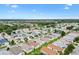 An aerial view of a residential community with charming single-story homes, mature trees, and a serene distant lake at 2317 Whisper St, The Villages, FL 32162