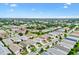 An aerial view showcases a meticulously planned residential community with lush trees and well-maintained homes under a clear blue sky at 2317 Whisper St, The Villages, FL 32162