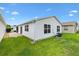 A well-maintained backyard with lush green lawn, white vinyl siding, and a comfortable space for outdoor enjoyment at 2317 Whisper St, The Villages, FL 32162