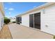 A clean outdoor patio with white vinyl siding and a sliding glass door, perfect for relaxation and easy access to the home at 2317 Whisper St, The Villages, FL 32162