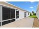 Relaxing outdoor patio with a screened-in section and vinyl siding, offering a comfortable and protected outdoor space at 2317 Whisper St, The Villages, FL 32162