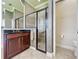 Bathroom showcases a walk-in shower, dark wood cabinets, dark granite countertops, and tile flooring at 243 Bayou Bend Rd, Groveland, FL 34736