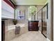Bathroom boasts walk-in shower, soaking tub, single sink vanity, large mirrors and tile flooring at 243 Bayou Bend Rd, Groveland, FL 34736