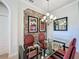 Stylish dining area featuring a glass table, elegant chandelier, and decorative wallpaper at 243 Bayou Bend Rd, Groveland, FL 34736