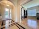 Inviting hallway with arched doorways, tile flooring, and views into the front entrance and an office at 243 Bayou Bend Rd, Groveland, FL 34736