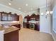Bright kitchen boasts stainless steel appliances, granite countertops, tile flooring, and a modern chandelier at 243 Bayou Bend Rd, Groveland, FL 34736