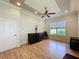 Bright living room featuring wood floors, a ceiling fan, and a large window with views of the outdoors at 243 Bayou Bend Rd, Groveland, FL 34736