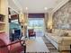 Inviting living room boasts a fireplace, built-in shelving, comfortable furniture and view to backyard at 243 Bayou Bend Rd, Groveland, FL 34736