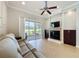 Cozy living room with a fireplace, sliding glass door leading to a patio, and comfortable seating at 243 Bayou Bend Rd, Groveland, FL 34736