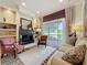 Cozy living room boasts a fireplace, built-in shelving, a striped rug, and sliding glass doors to the backyard at 243 Bayou Bend Rd, Groveland, FL 34736