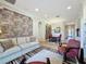 Inviting living room features stylish accent wall, comfortable sofa, dining set and view to the front entrance at 243 Bayou Bend Rd, Groveland, FL 34736