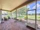 Screened patio with brick flooring, comfortable seating, and scenic backyard views at 243 Bayou Bend Rd, Groveland, FL 34736