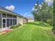 A lush backyard features beautiful landscaping, a well-maintained lawn, and a screened in porch at 25222 Laurel Valley Rd, Leesburg, FL 34748